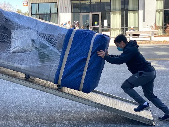 Professional movers carefully loading furniture into a moving truck